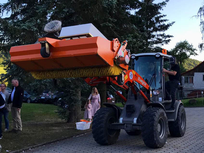 Radlader mit Kehrmaschinen-Aufsatz bei Aufräumarbeiten