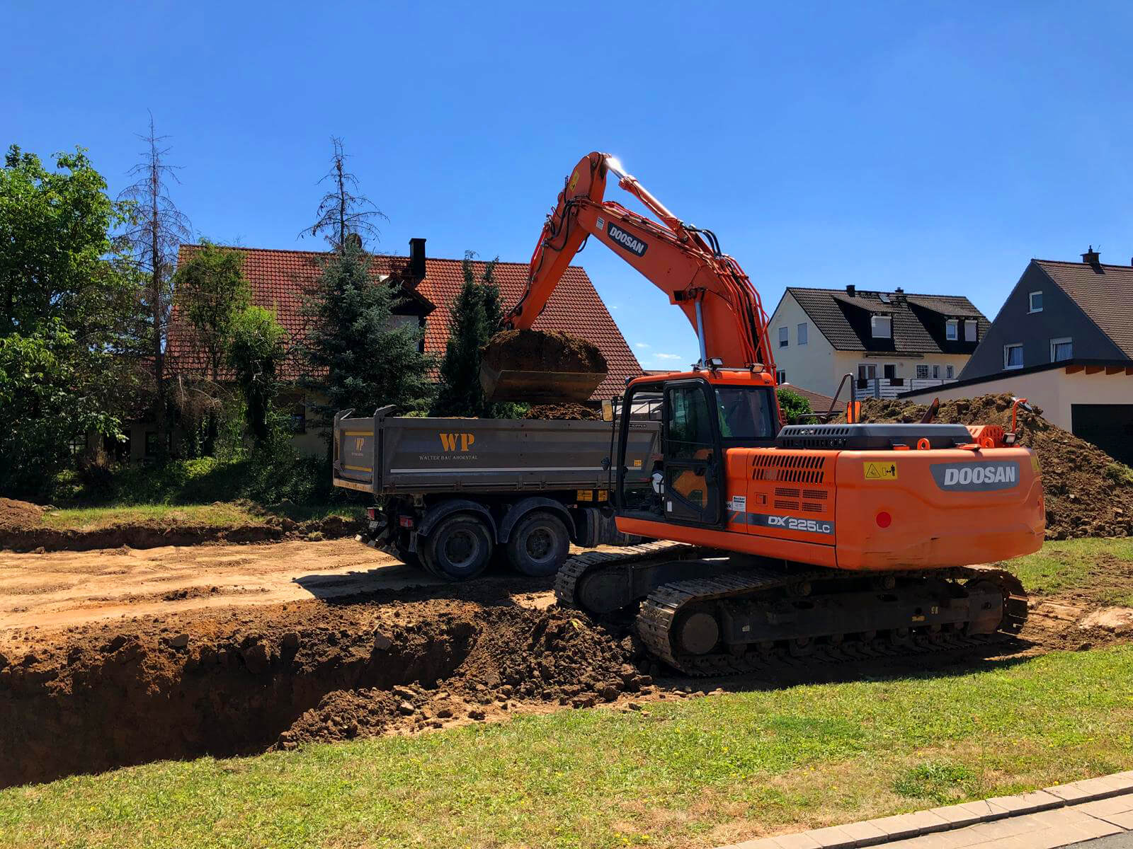 Kettenbagger und § Seiten-Kipper LKW bei der Verlegung von Fernwärme